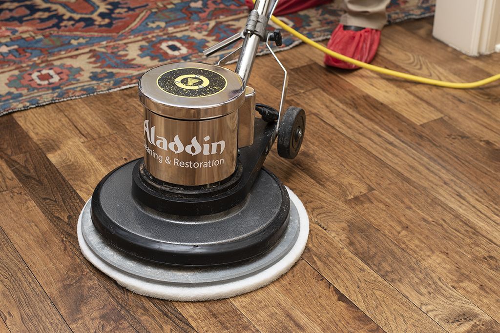 Professional machine cleaning a wooden floor.