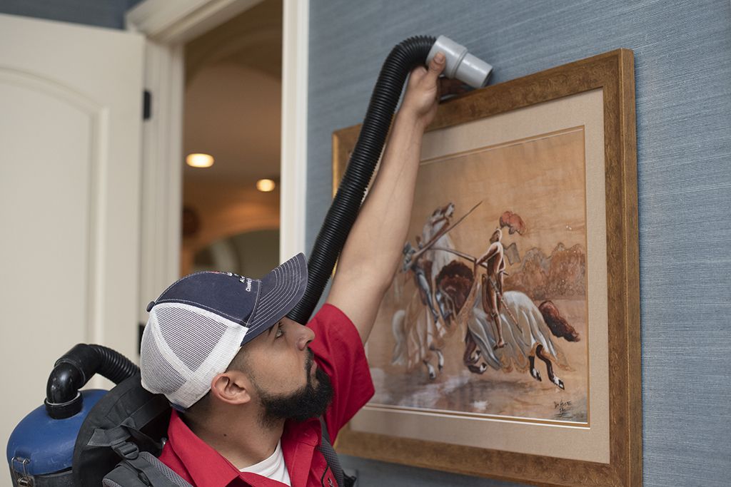 Aladdin cleaning specialist cleans up work area after air duct cleaning