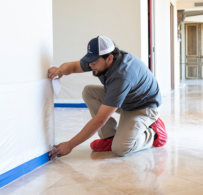 An Aladdin cleaning specialist protects walls, baseboards and other surfaces adjacent to the natural stone area