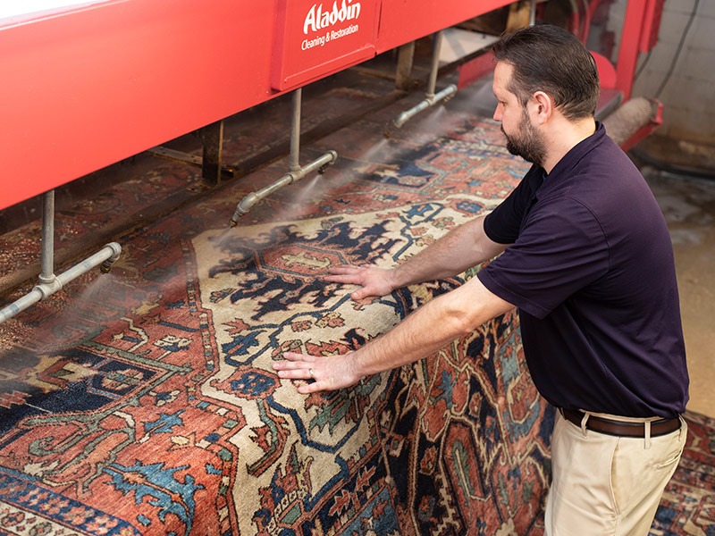 AlCl_2for1_CertifiedRugCareSpecialist Aladdin Employees Running Rug thru a cleaning machine.