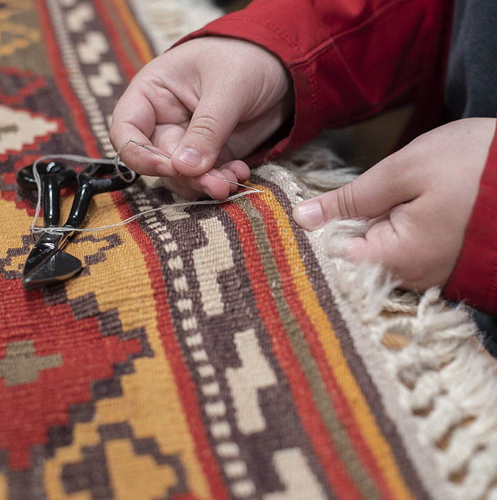 RR_Inset_2021 Aladdin Employee repairing rug.