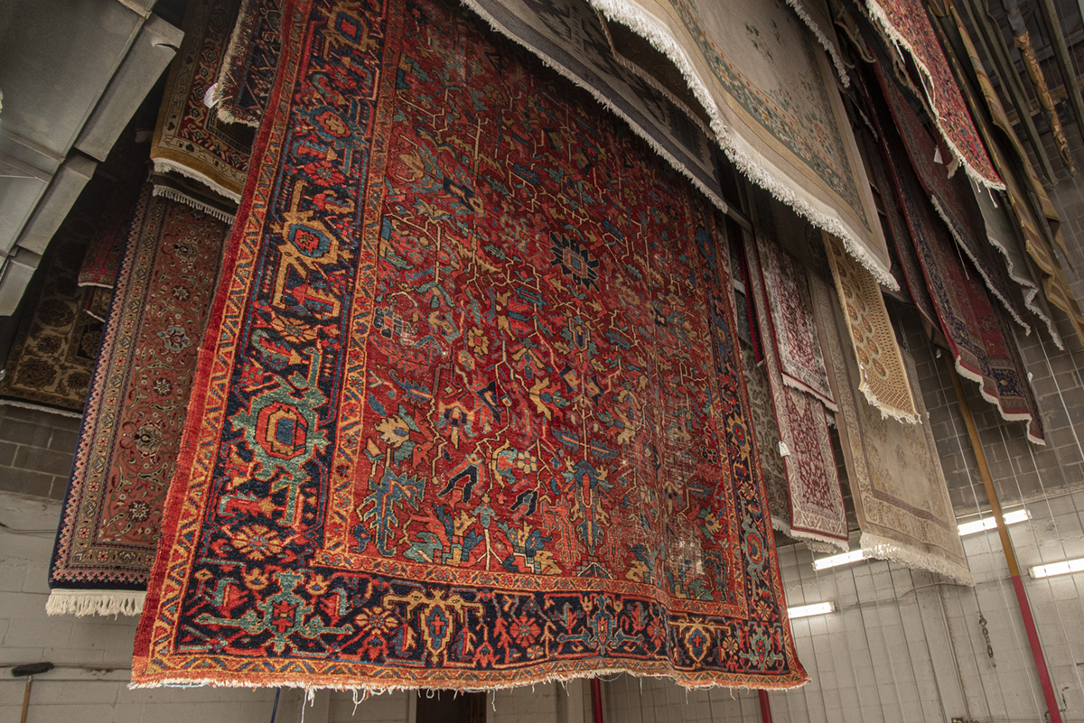 Oriental rugs hanging in humidity- and temperature-controlled drying room to prevent improper drying and mold