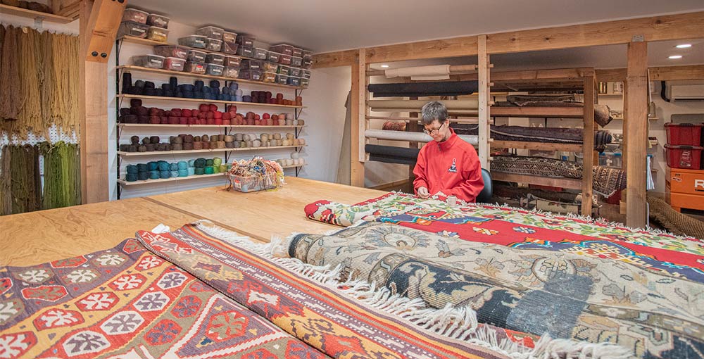 Aladdin Employee repairing rug.